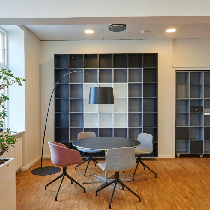 Bright and stylish office space with contemporary furniture and open shelving.